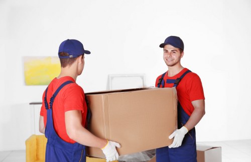Office relocation team organizing IT equipment and labeled boxes in Westend